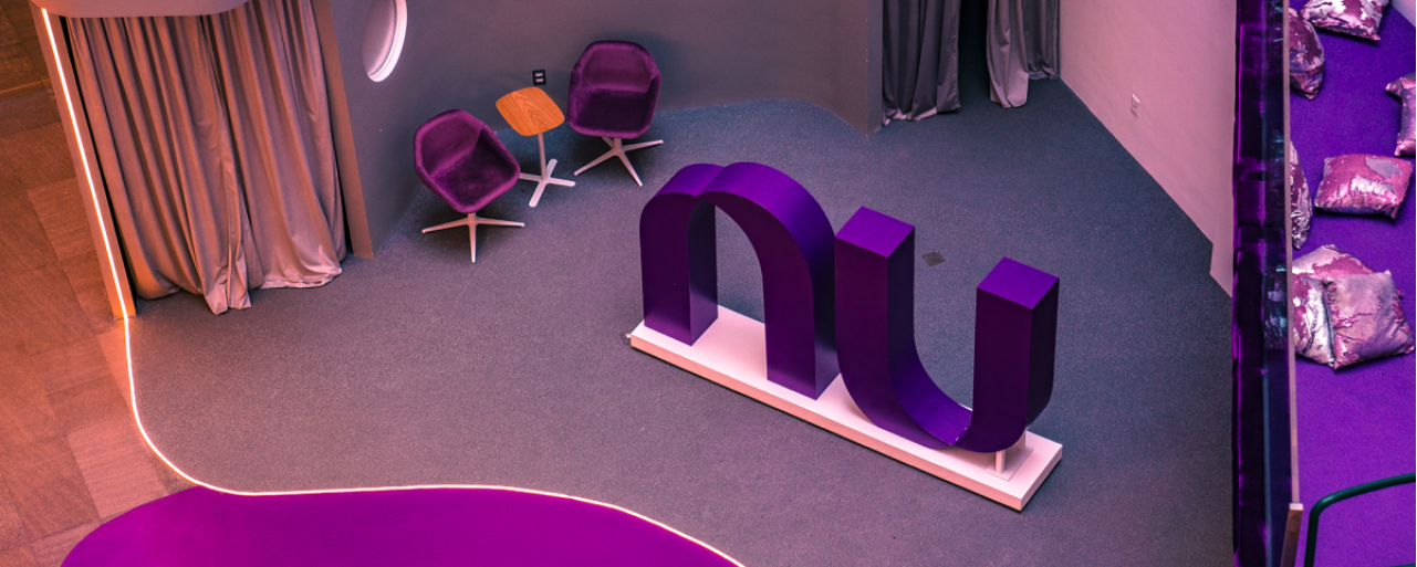 Purple Nu logo in Sao Paulo Office with gray mat and two purple chairs